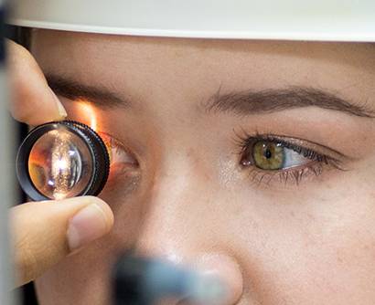 Close-up of a patient undergoing an eye examination with a light instrument.