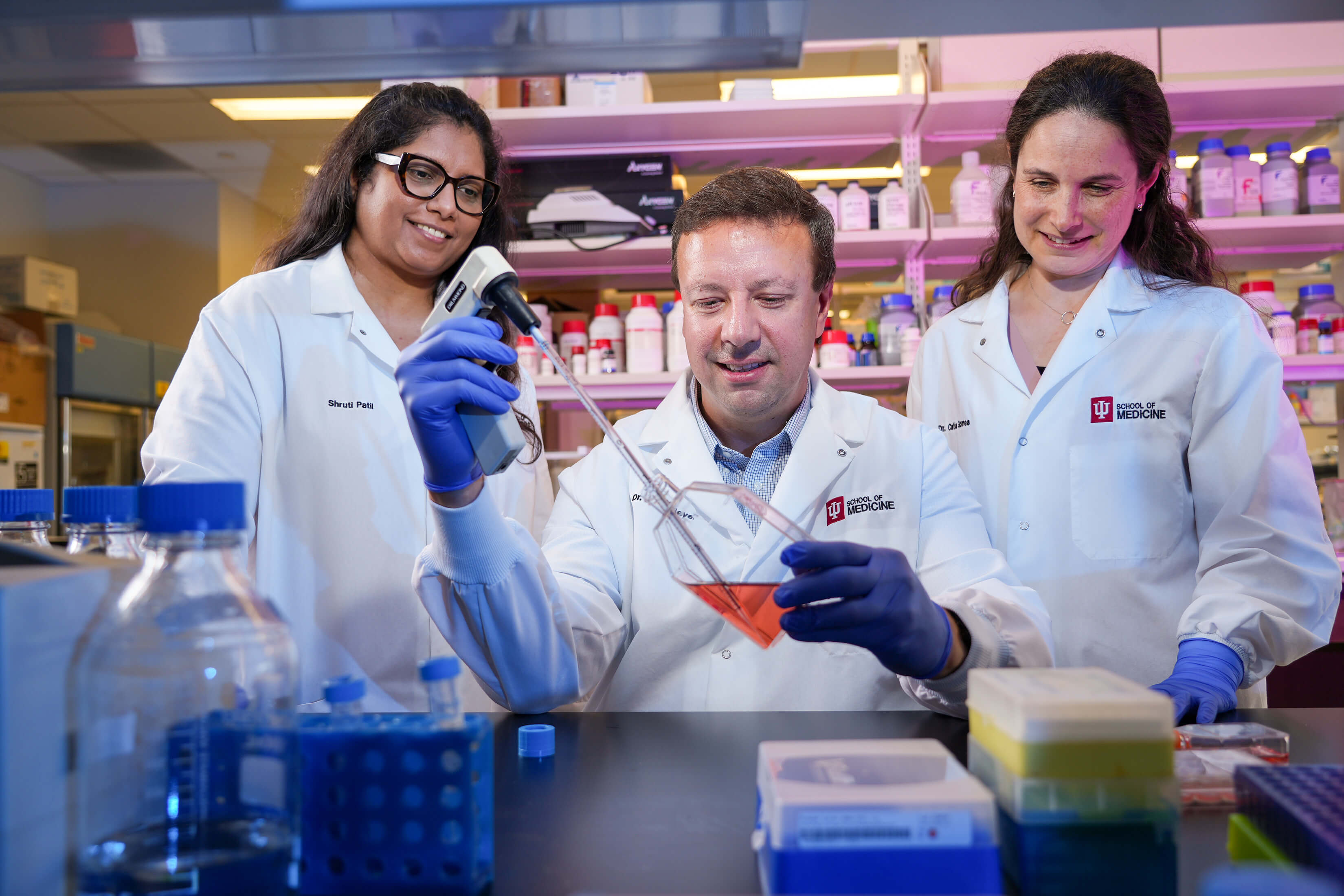 Jason Meyer, PhD working with two team members in his lab.