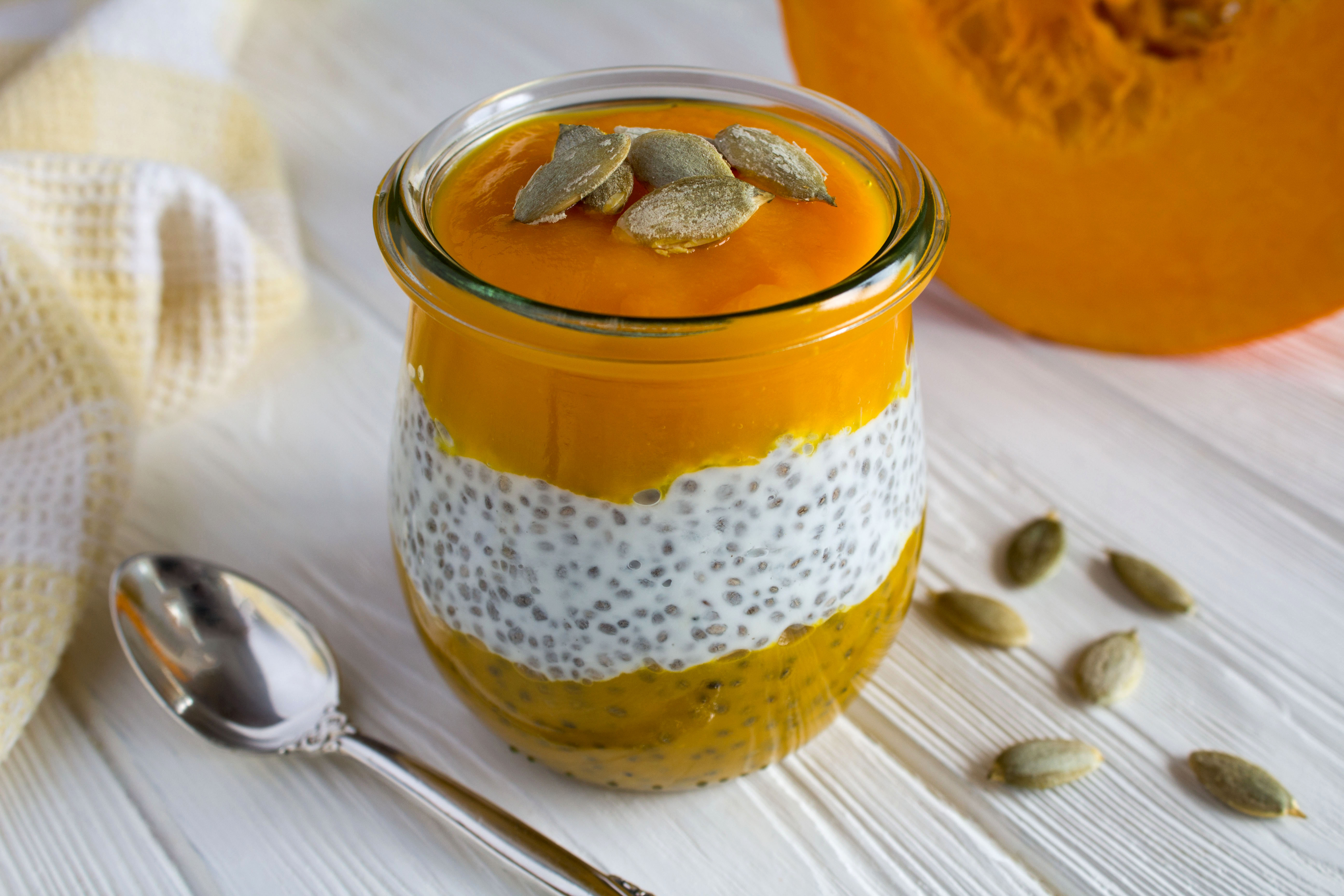 Pudding with chia seed and pumpkin on the white wooden background. Close-up.